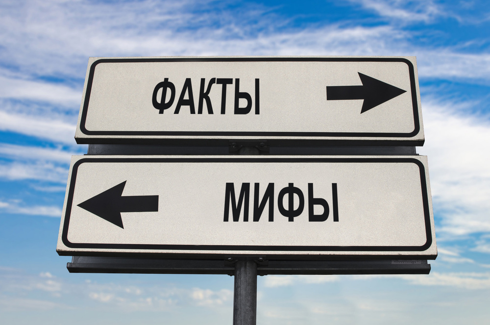 Изображение. Факт против мифа: дорожный знак с двумя стрелками на фоне голубого неба с облаками