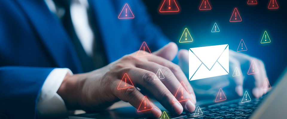 Изображение. Руки человека работают за ноутбуком на фоне предупреждающих знаков безопасности электронной почты