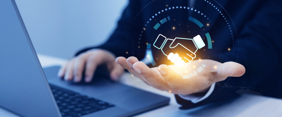 Изображение. Концепция делового сотрудничества. Цифровое изображение рукопожатия в руке бизнесмена, сидящего перед ноутбуком