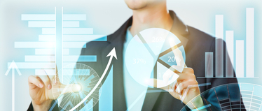 Изображение. Бизнесмен перед виртуальными графиками и схемами