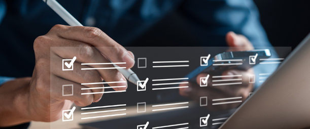 Изображение. Мужчина перед ноутбуком делает отметки в виртуальном списке