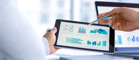 Изображение. Рука человека с помощью стилуса взаимодействует с графиками и диаграммами на планшете