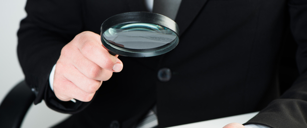 Изображение. Рука держит увеличительное стекло над контрактом