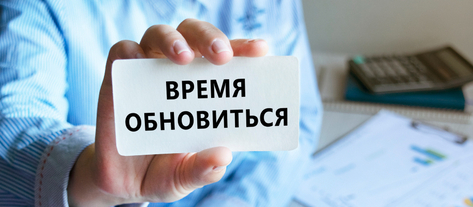 Изображение. Визитка крупным планом с надписью "Время обновиться" в руке офисного сотрудника
