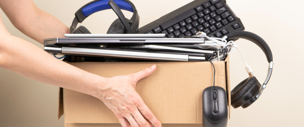 Изображение. Руки держат картонную коробку, из которой выглядывают клавиатура, мышь, наушники и ноутбук