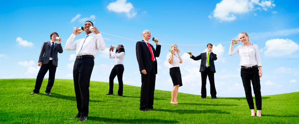 Изображение. Офисные сотрудники в деловой одежде общается с помощью игрушечных приспособлений на фоне зелёного поля и ясного неба