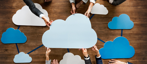 Изображение. Сотрудники за рабочим столом держат в руках бумажную фигуру в виде облака