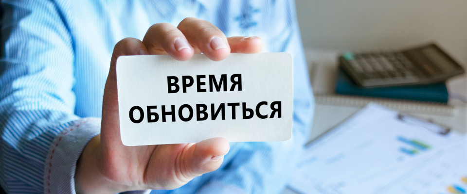 Изображение. Визитка крупным планом с надписью "Время обновиться" в руке офисного сотрудника